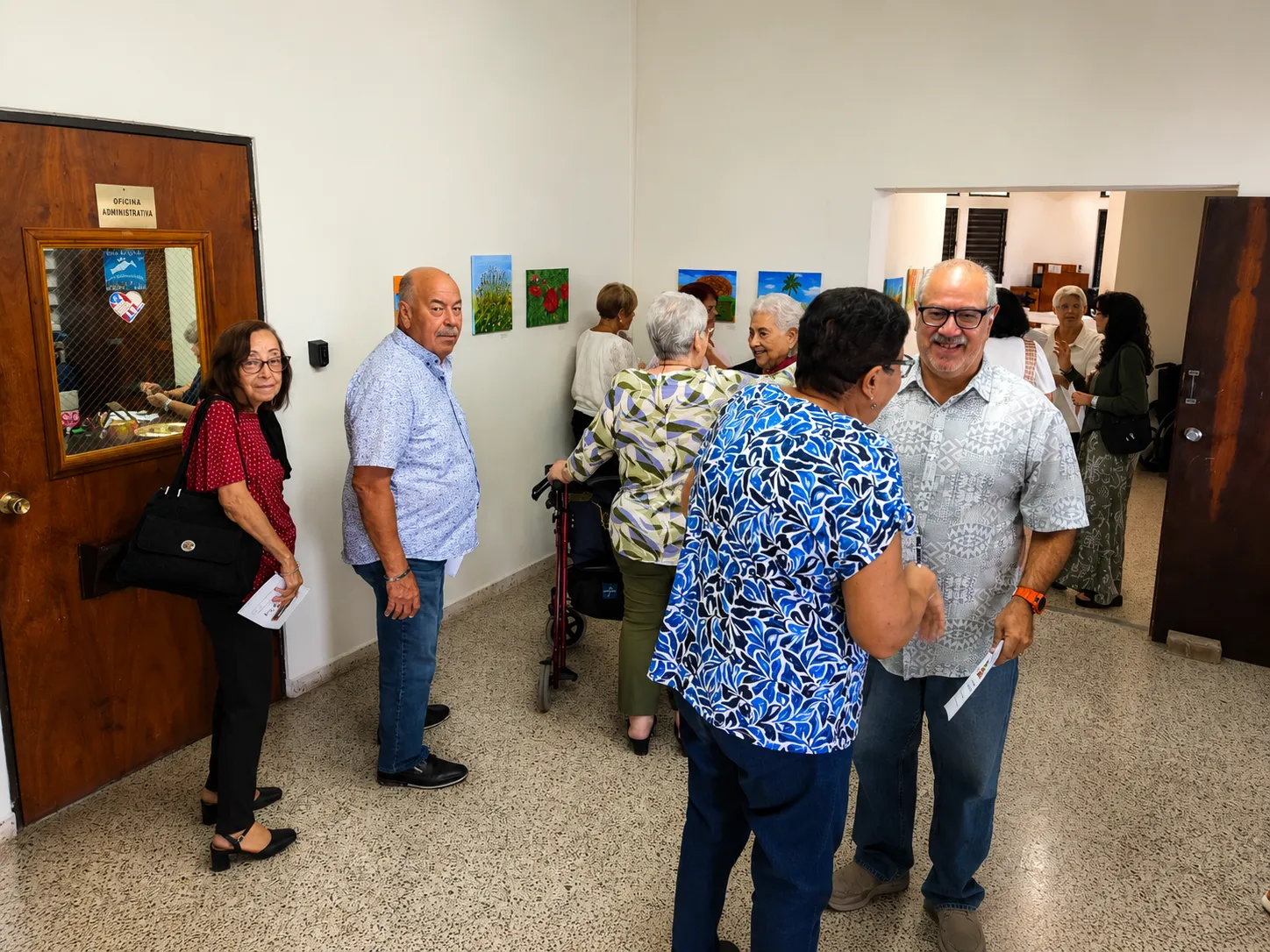 Visitantes conversan mientras recorren la galería de la exposición